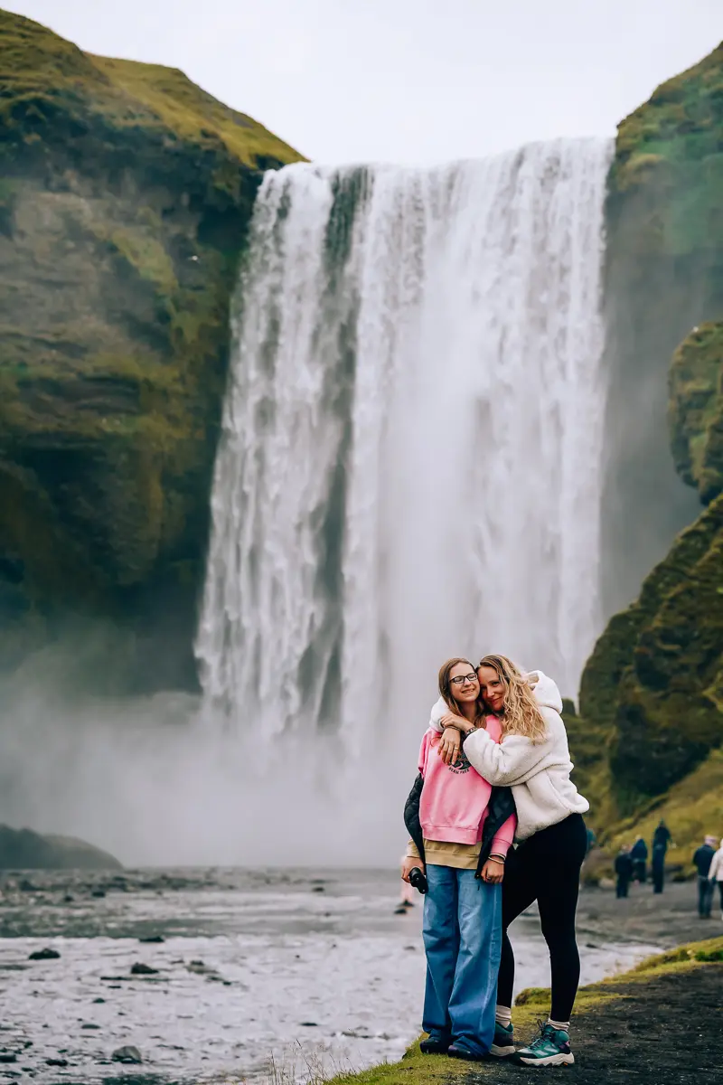 Elena and Alexis hugging in front of a waterfall