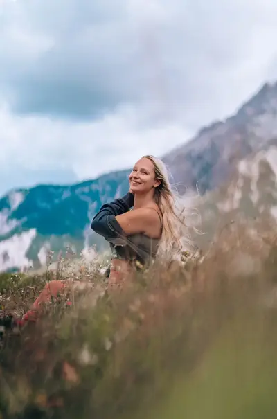 Elena standing among mountain wildflowers