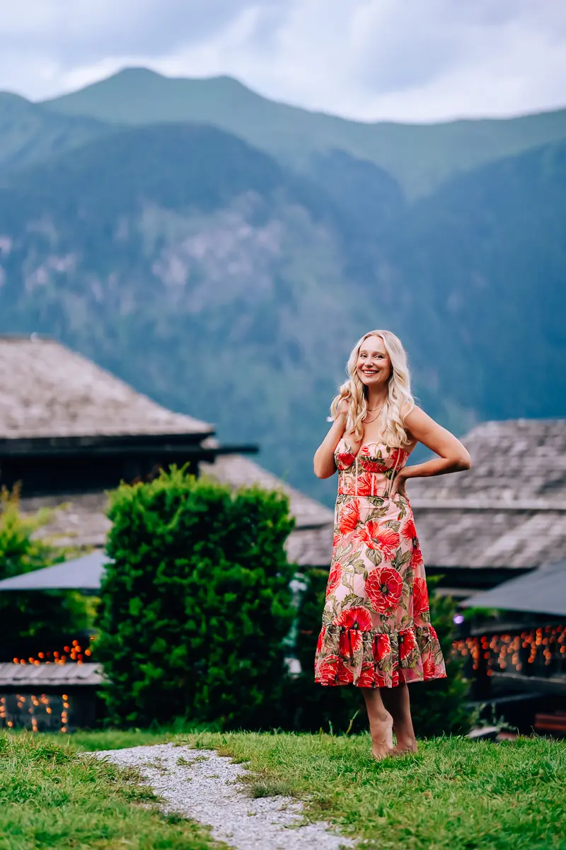Elena standing in a floral dress in the mountains