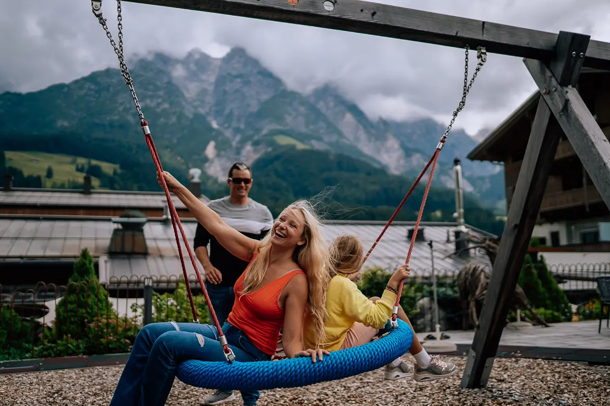 Elena laughing with her family on a mountain swing