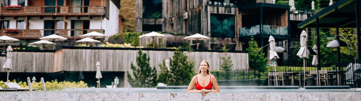 Elena standing at a mountain resort pool
