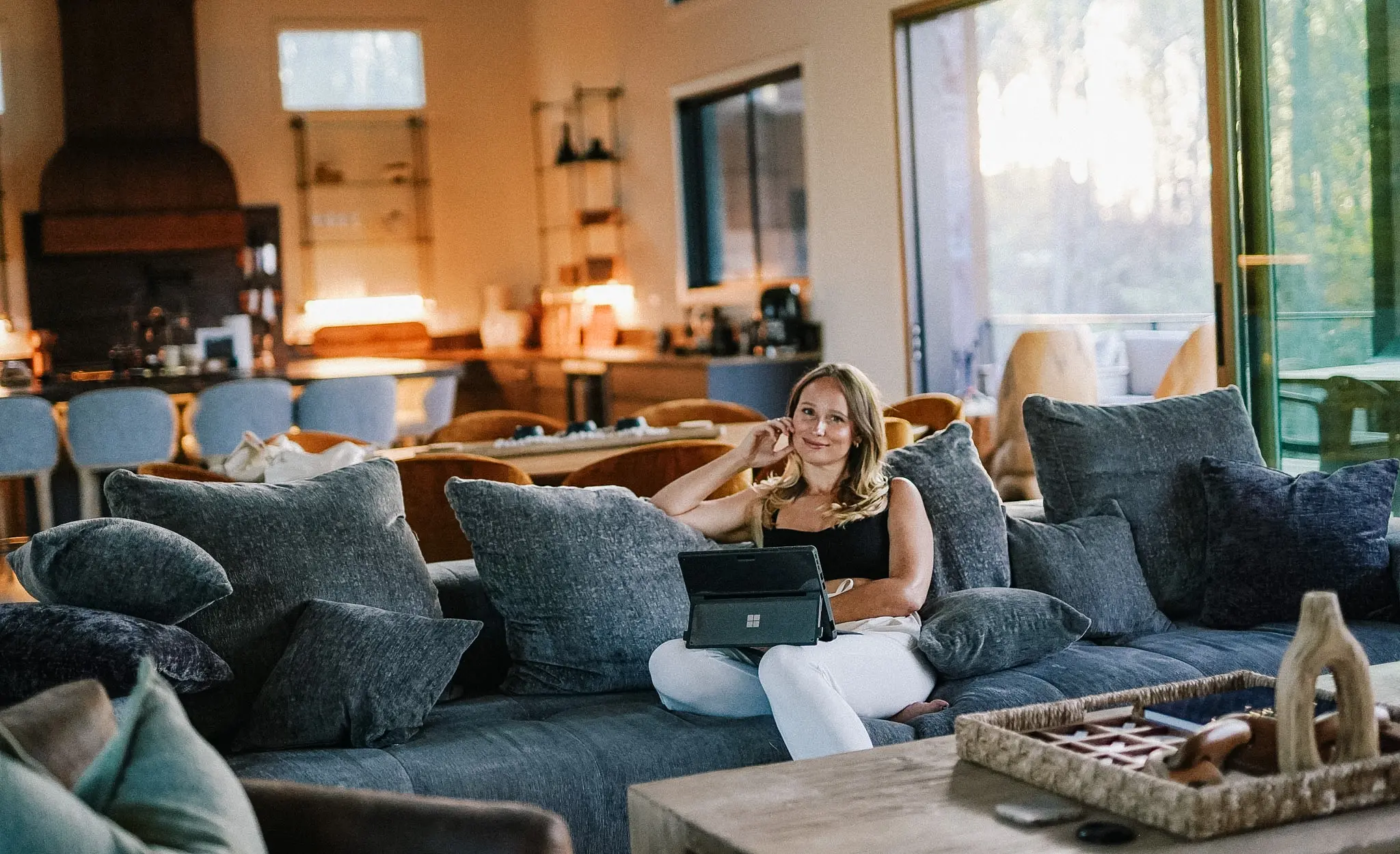 Elena relaxing on a couch with her laptop