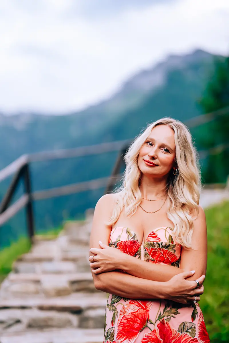 Elena in a floral dress in front of the mountains