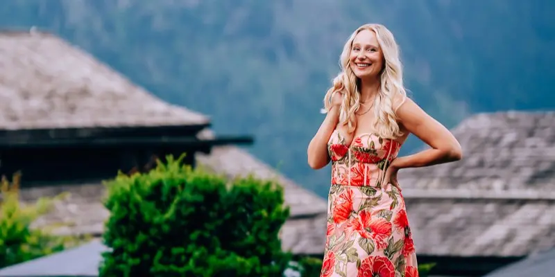 Elena smiling in a floral dress in the mountains